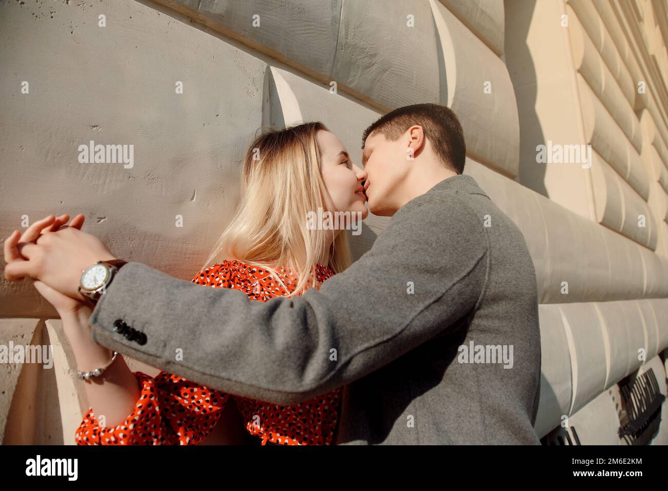 Concetto di relazioni d'amore uomo e donna. Bella coppia che cammina nella grande città, abbracciandosi, baciandosi e godendosi a vicenda. Foto Stock