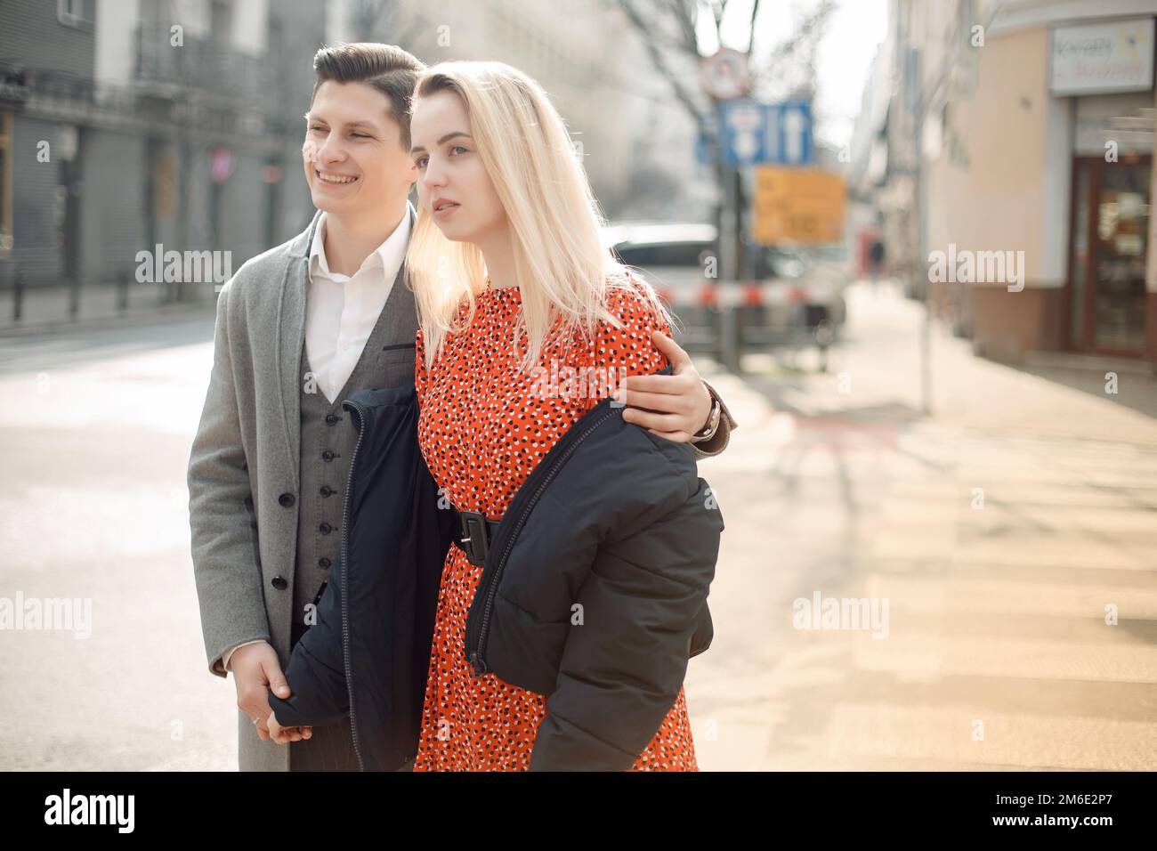 Concetto di relazioni d'amore uomo e donna. Bella coppia che cammina nella grande città, abbracciandosi, baciandosi e godendosi a vicenda. Foto Stock