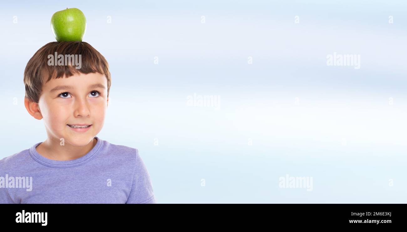 Apple frutta bambino ragazzo sulla sua testa banner copyspace copia spazio mangiare sano Foto Stock