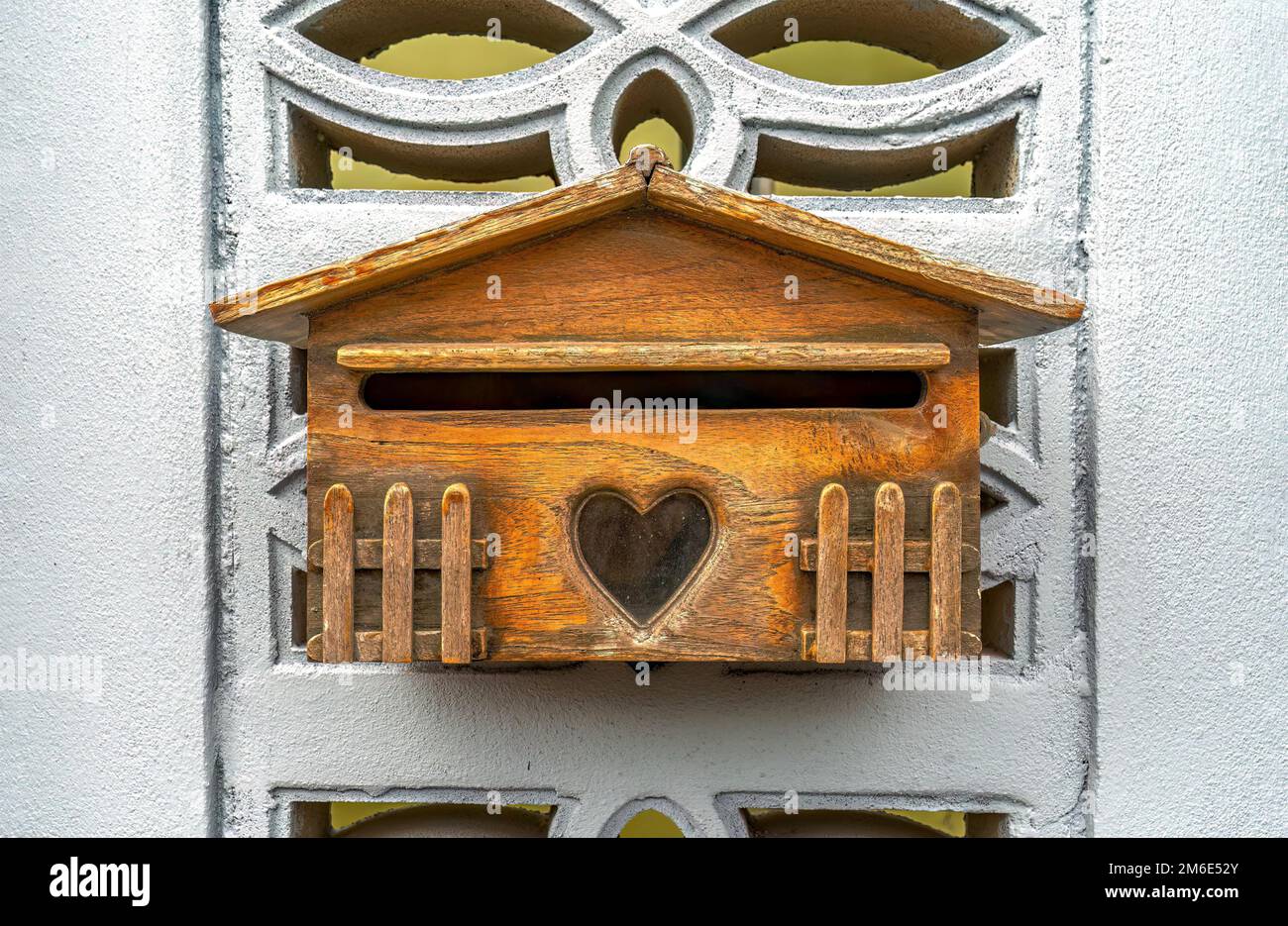 Belle cassette postali in legno mini appese su un muro di cemento, con uno sfondo isolato e clipping percorso. Foto Stock