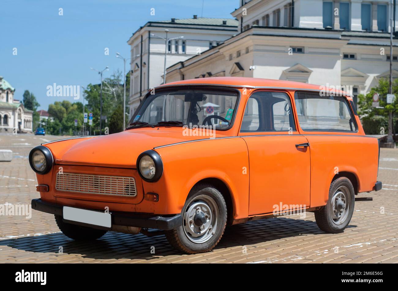 Auto Trabant restaurata in color arancio su strada lastricata Foto Stock