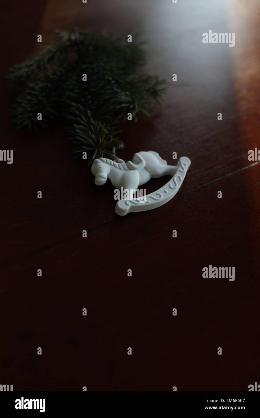 Albero di Natale, cavallo giocattolo, scatola regalo, cono di pino su un tavolo di legno sfondo vista dall'alto. Decorazione di casa di Capodanno Foto Stock