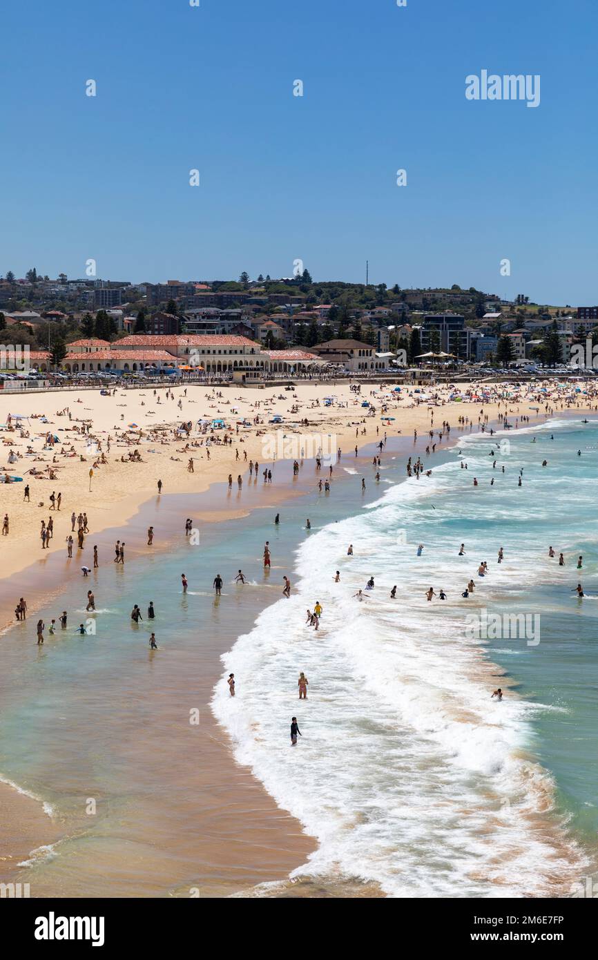 Estate 2023, Bondi Beach Sydney in una giornata di estate con cielo blu chiaro, spiaggia piena e affollata con persone che prendono il sole e nuotano, Sydney, NSW, Australia Foto Stock