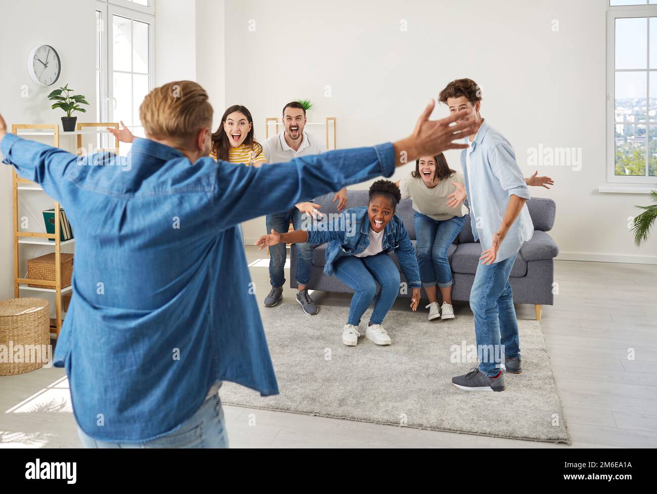 Uomo felice che si stenderà le braccia per abbracciare i suoi amici quando li vede dopo molto tempo Foto Stock