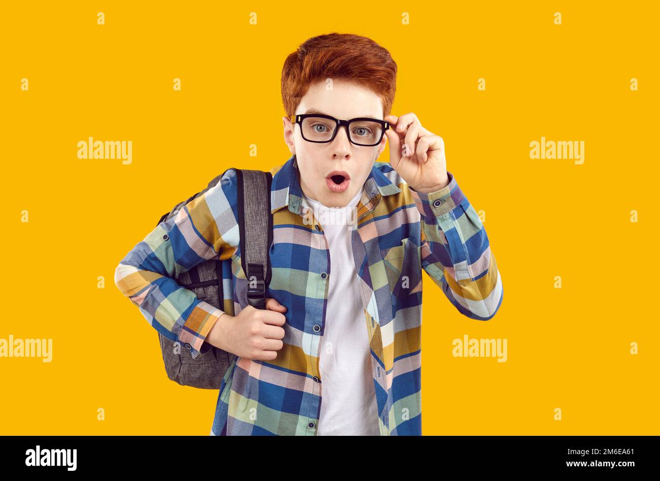 Ritratto del bambino di scuola in occhiali guardando la macchina fotografica con l'espressione del viso sorpreso Foto Stock