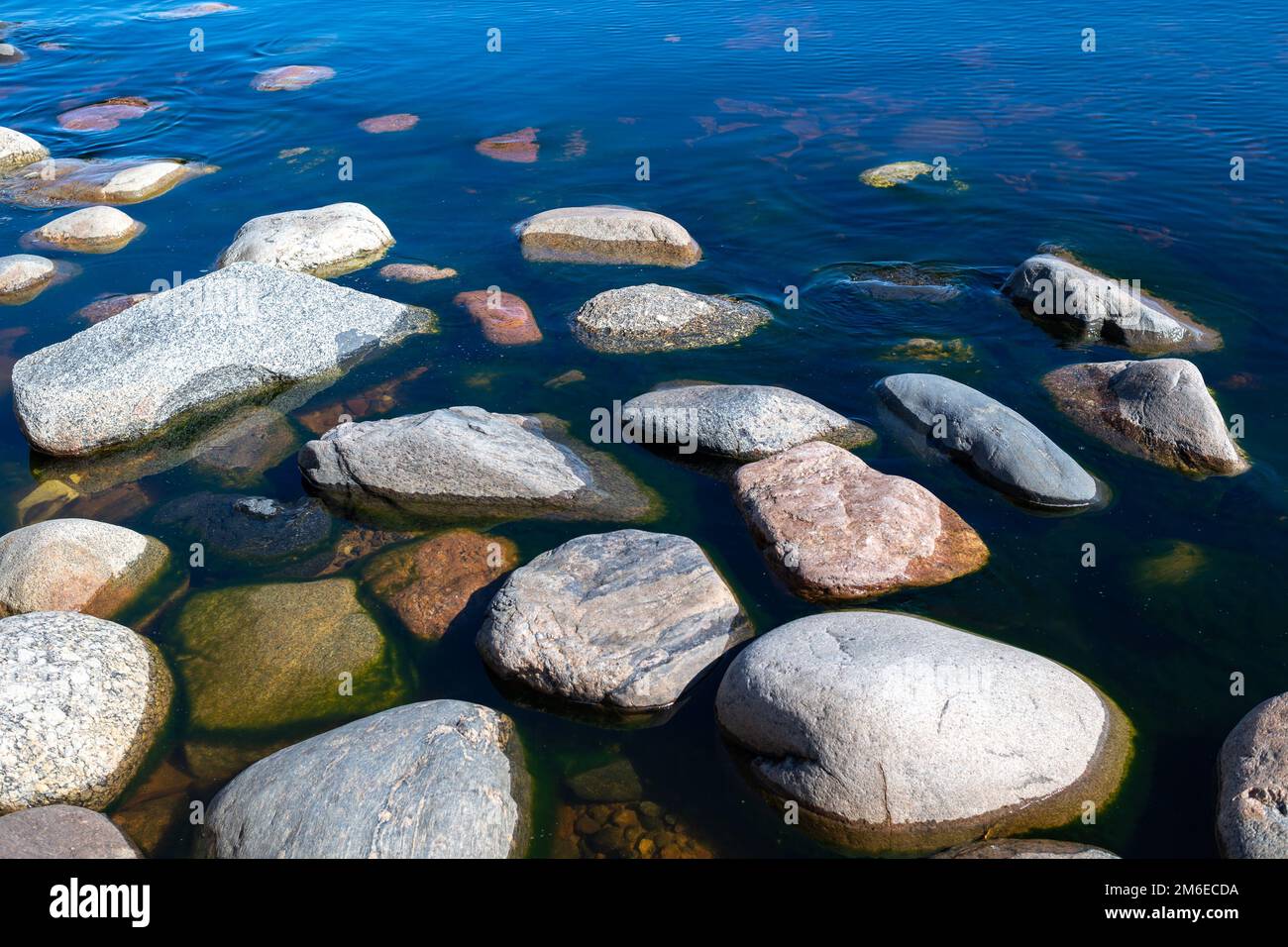 Pietre in acqua limpida e blu lago. Lago Ladoga, Russia. Foto Stock