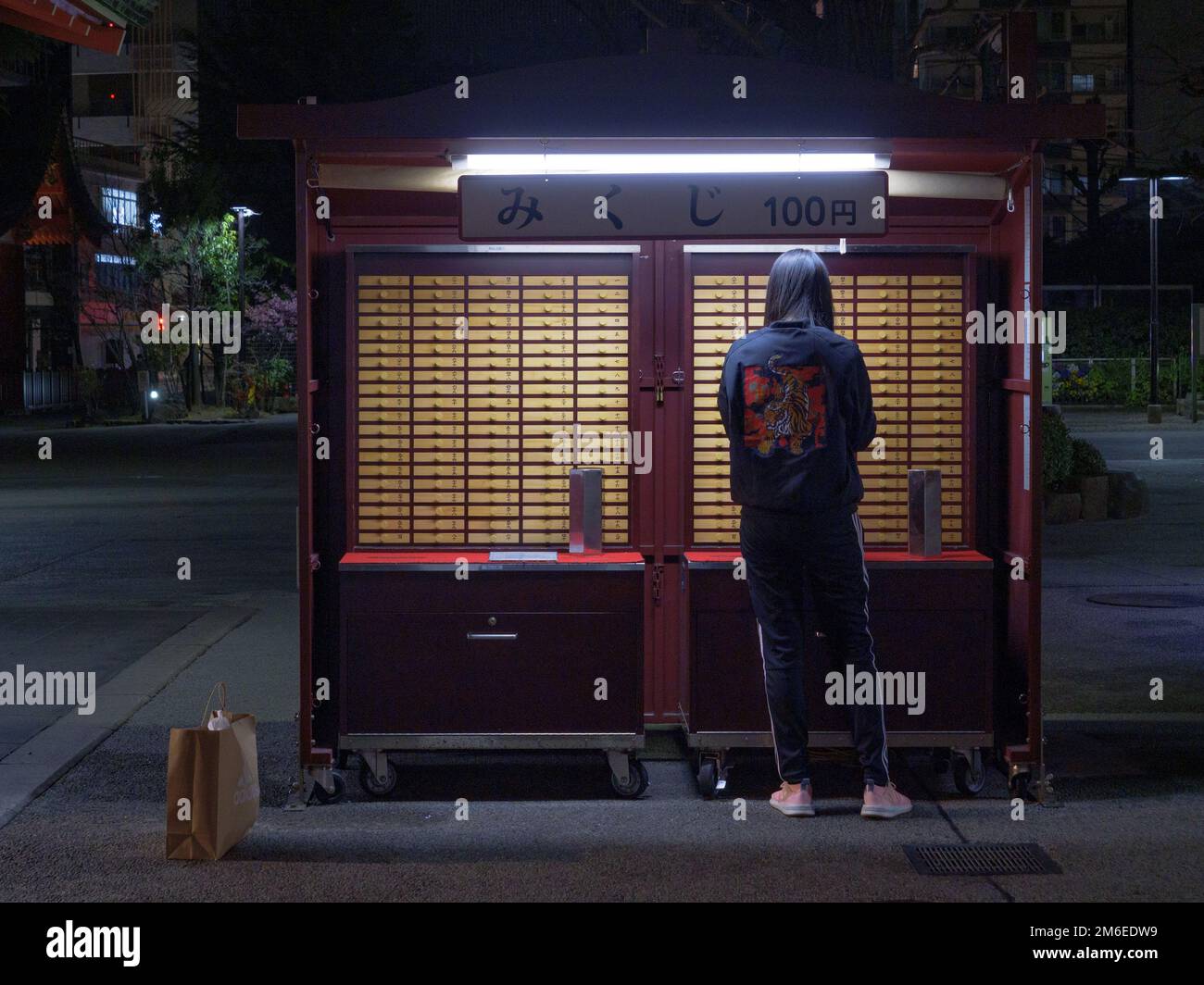 Tokyo, Giappone - 24.2.20: Un visitatore a sensoji ottenere la loro fortuna Foto Stock