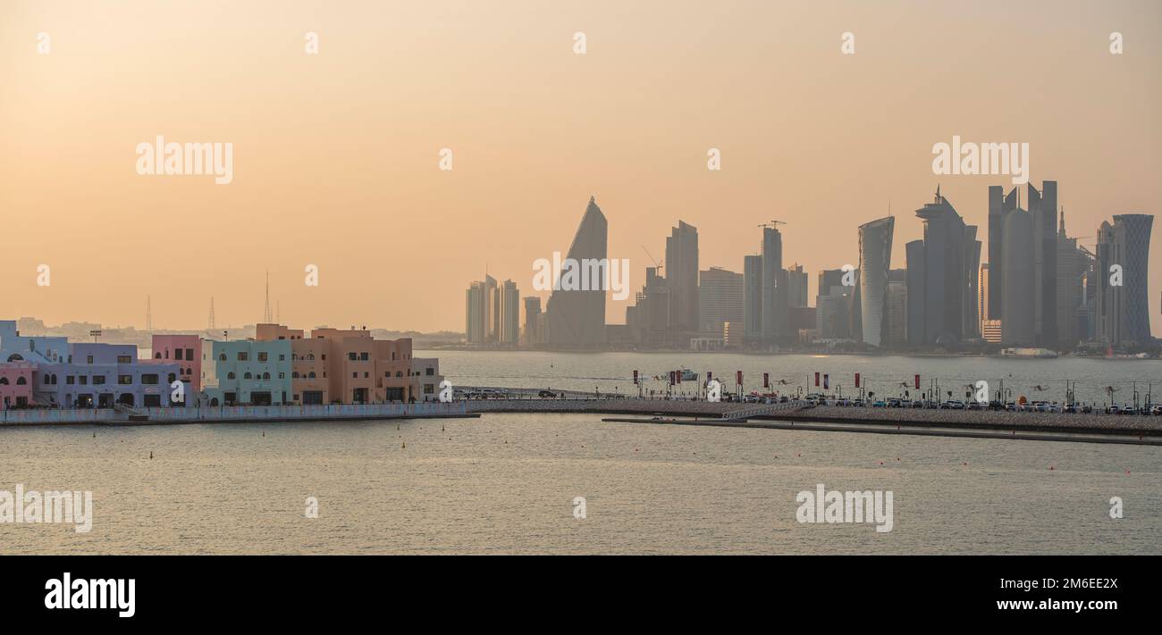 Mina District Corniche (a sinistra) e gli edifici sul lungomare di Doha, Qatar, tra cui la Torre Tornado, chiamata anche Torre QIPCO, il Burj Doha Foto Stock
