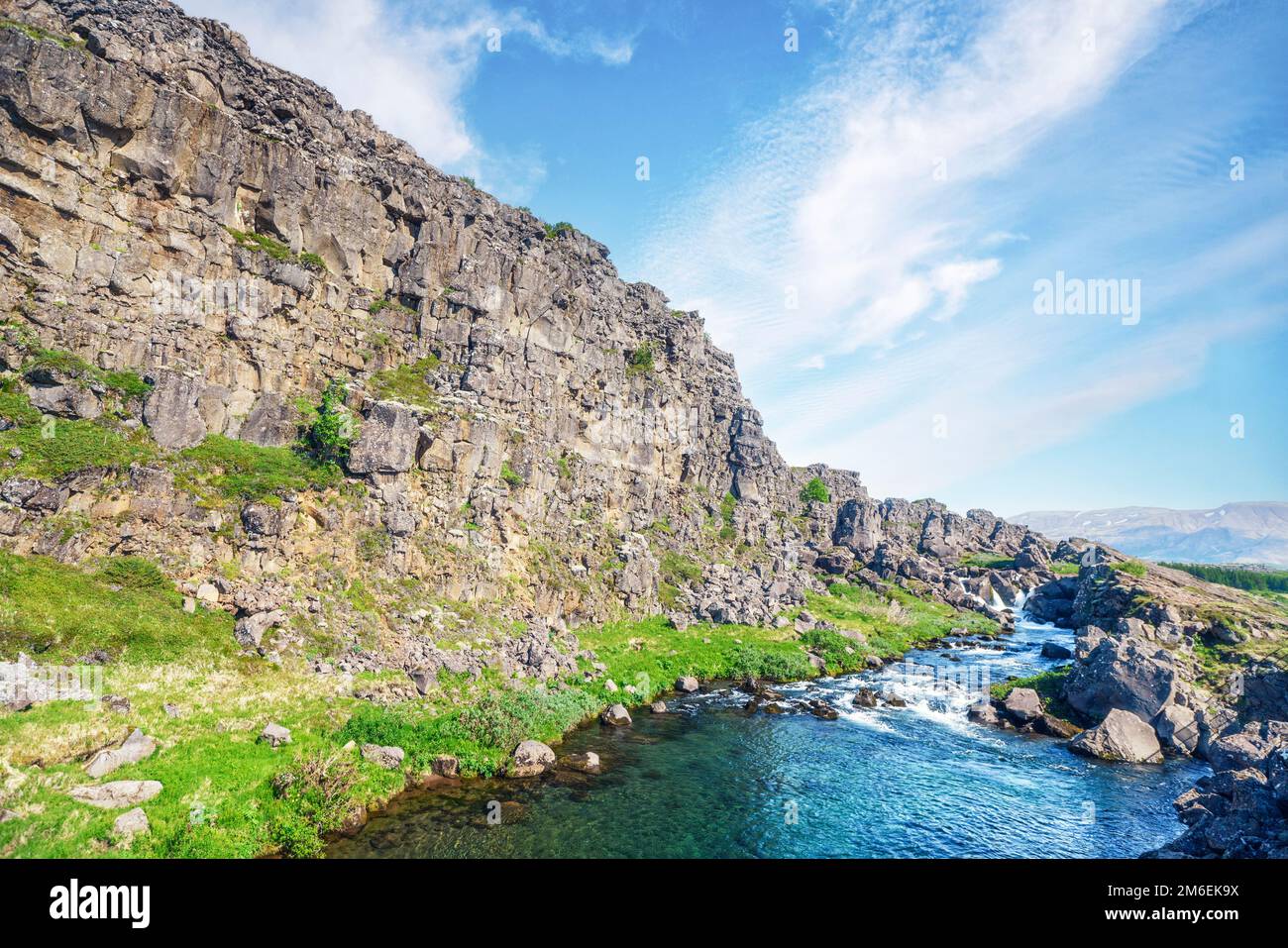 Torrente di montagna witt alte scogliere e grandi rocce in estate in Islanda Foto Stock