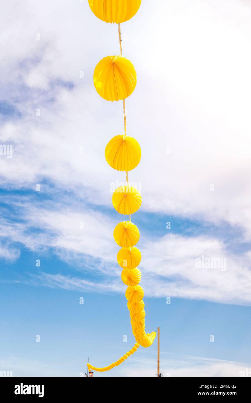 Lanterne di carta gialla appese su un filo sotto un cielo blu nel tempo di  sole Foto stock - Alamy