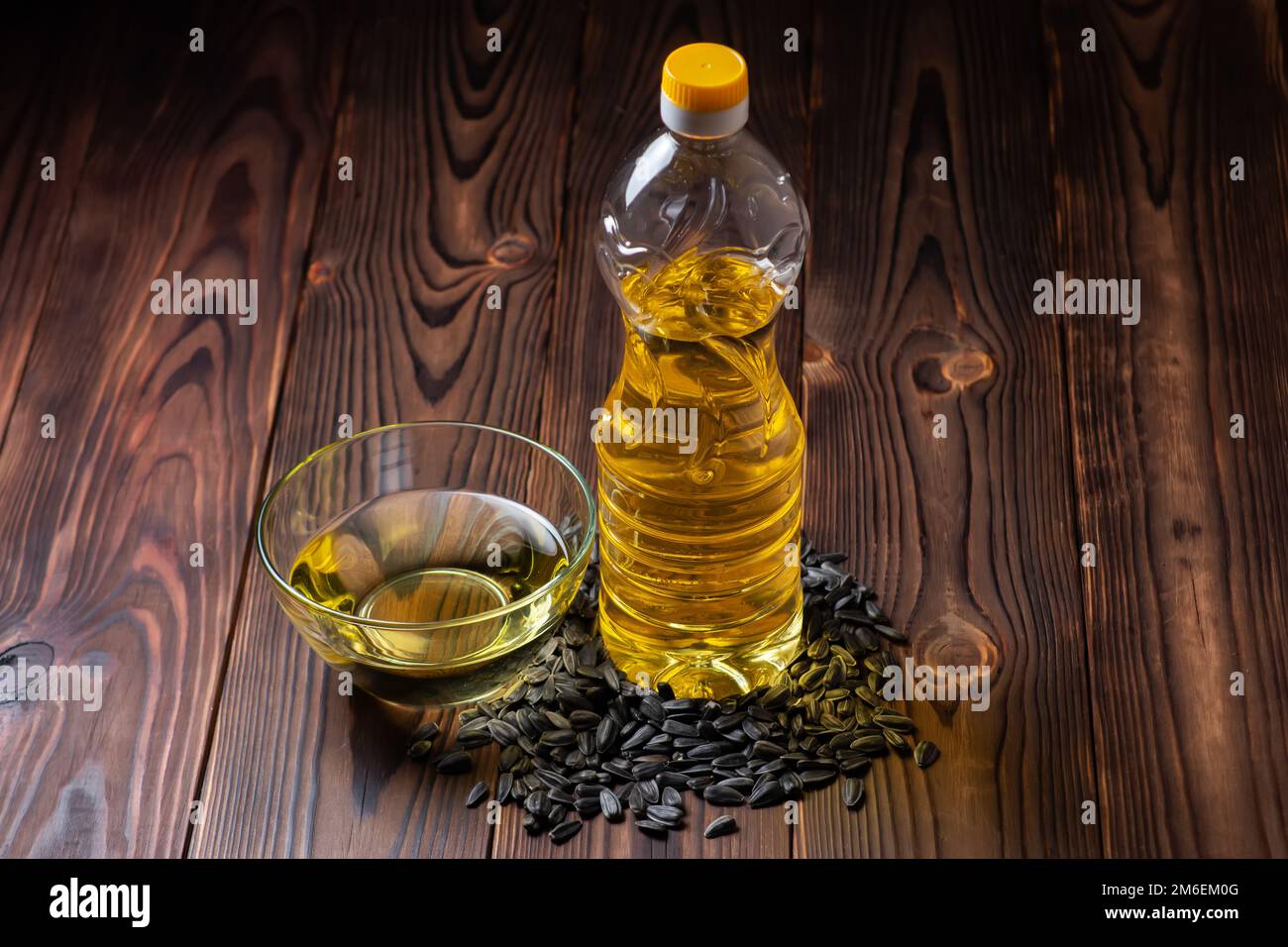 Olio di girasole biologico in una ciotola di vetro e bottiglia con semi di girasole Foto Stock