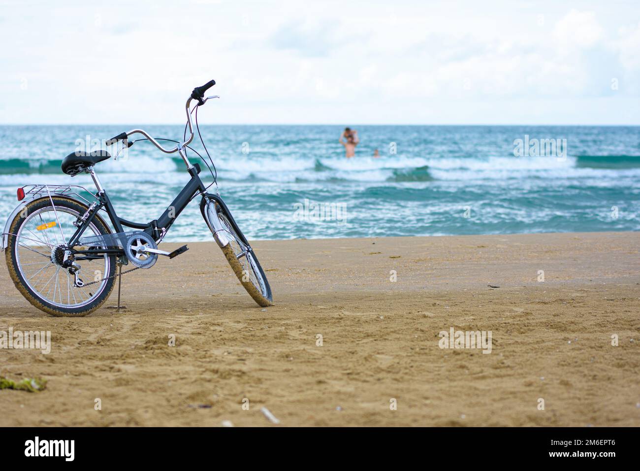 La bicicletta si trova sulla spiaggia di sabbia Foto Stock