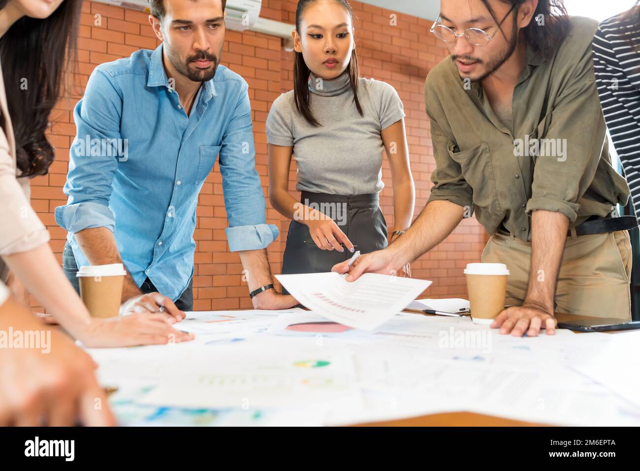 Primo piano brainstorming del team Aziende nella sala riunioni con maschera facciale. Foto Stock