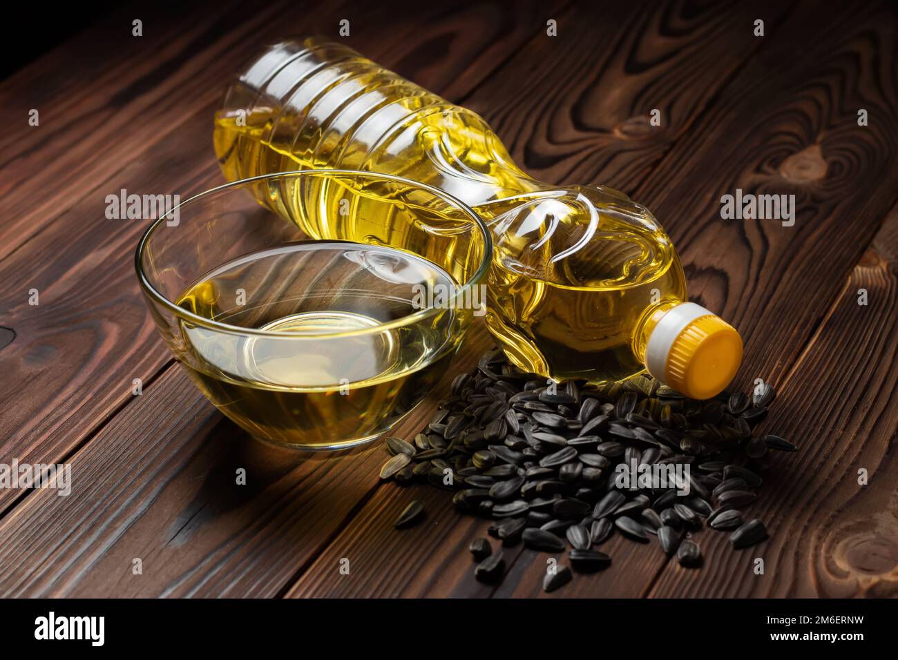 Olio di girasole biologico in una ciotola di vetro e bottiglia con semi di girasole Foto Stock