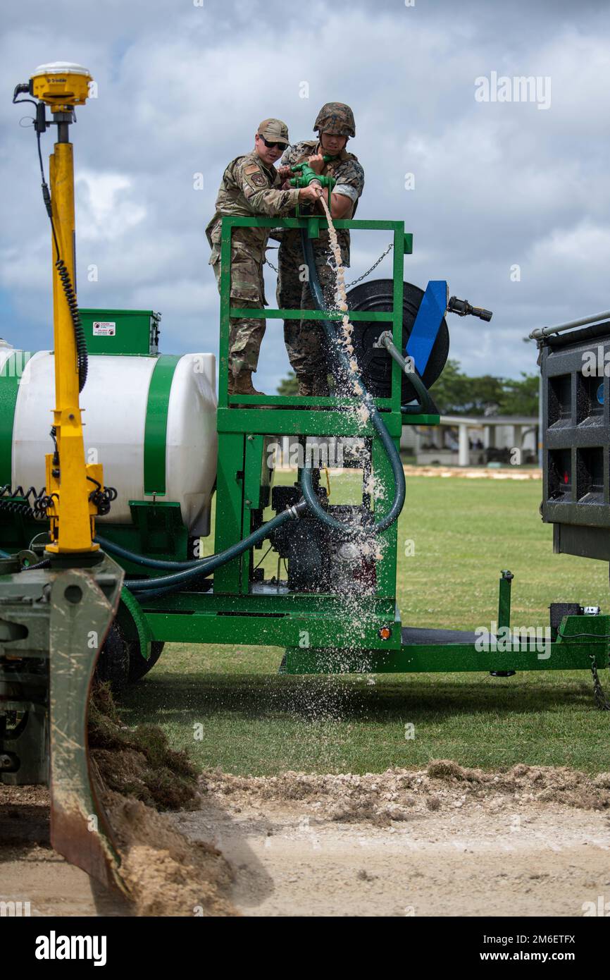 Airman 1st Class Gabriel barba, sinistra, 18th ingegnere civile Squadron pavimentazione e operatore di attrezzature, e Lance CPL. Fernando Figueroa, destra, Marine Wing Support Squadron 172 meccanico di attrezzature pesanti, gestire un 18th CES Hydroseeder a Camp Futenma, Giappone, 26 aprile 2022. L'Hydroseeder è stato utilizzato per completare un rinnovamento del binario, fornendo al contempo formazione sulle attrezzature sia per gli Airmen che per i Marines coinvolti. Foto Stock
