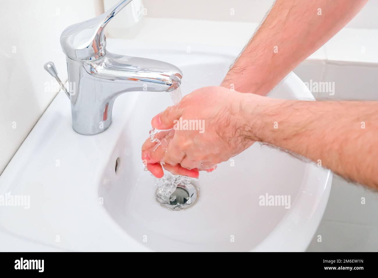 L'uomo si lava le mani. Lavarsi nella sala di trattamento Foto Stock