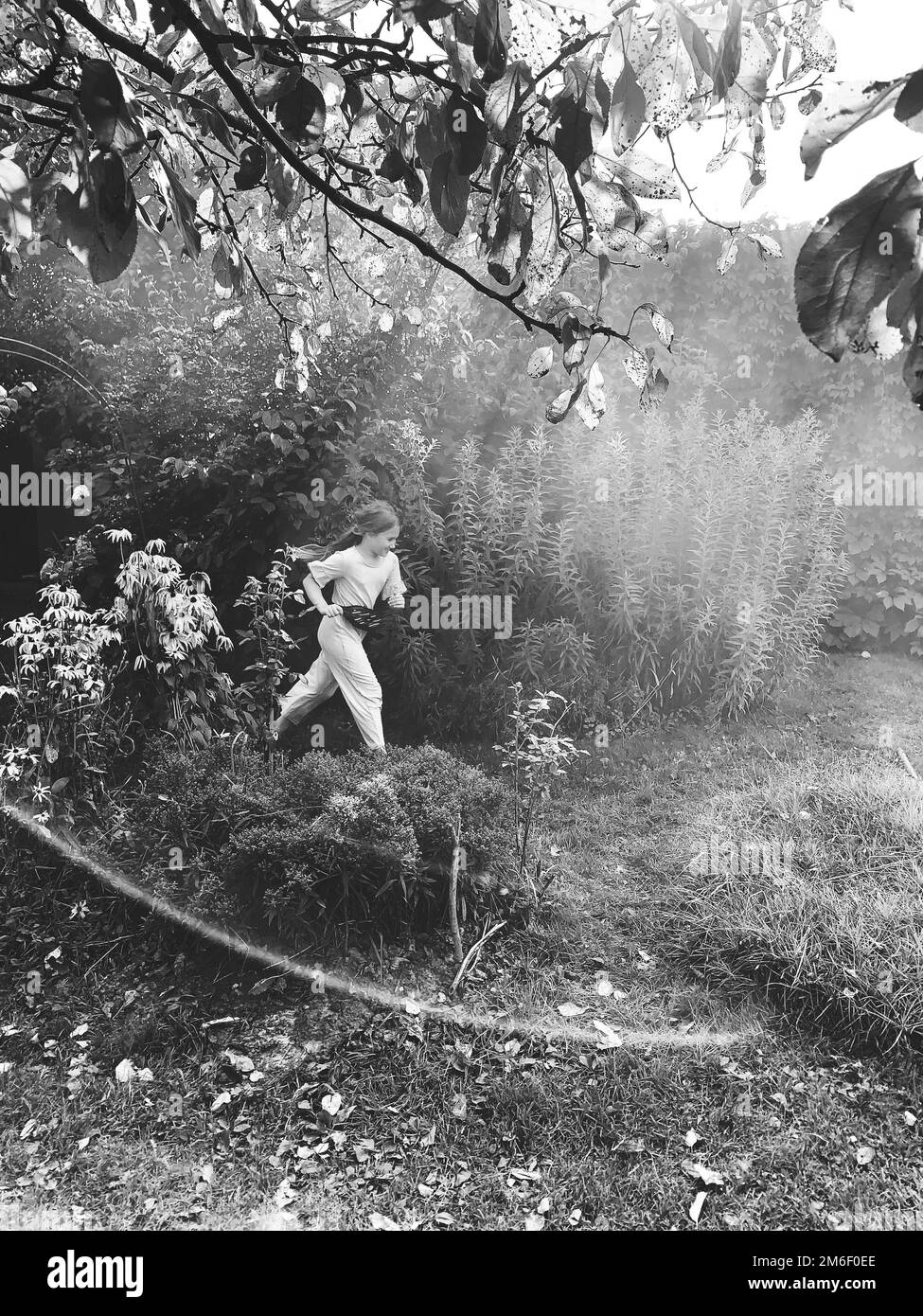 Ragazza che soffia bolle con pistola a bolle Foto Stock