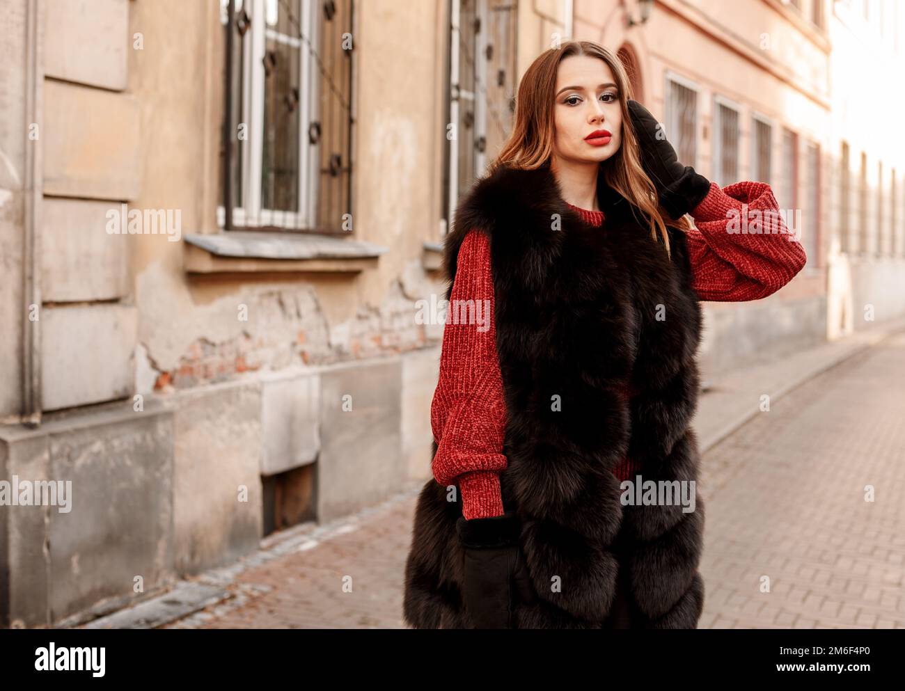 Foto all'aperto della modella femminile alla moda che cammina per la città in vacanza invernale. Ragazza alla moda che cammina sulla strada di Varsavia in o Foto Stock
