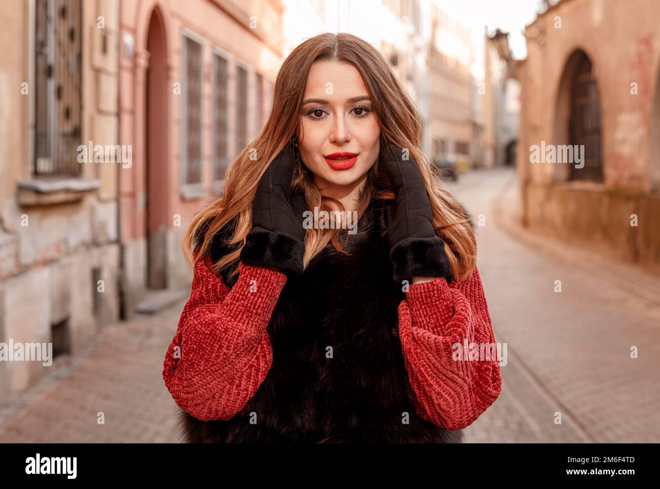 Foto all'aperto della modella femminile alla moda che cammina per la città in vacanza invernale. Ragazza alla moda che cammina sulla strada di Varsavia in o Foto Stock