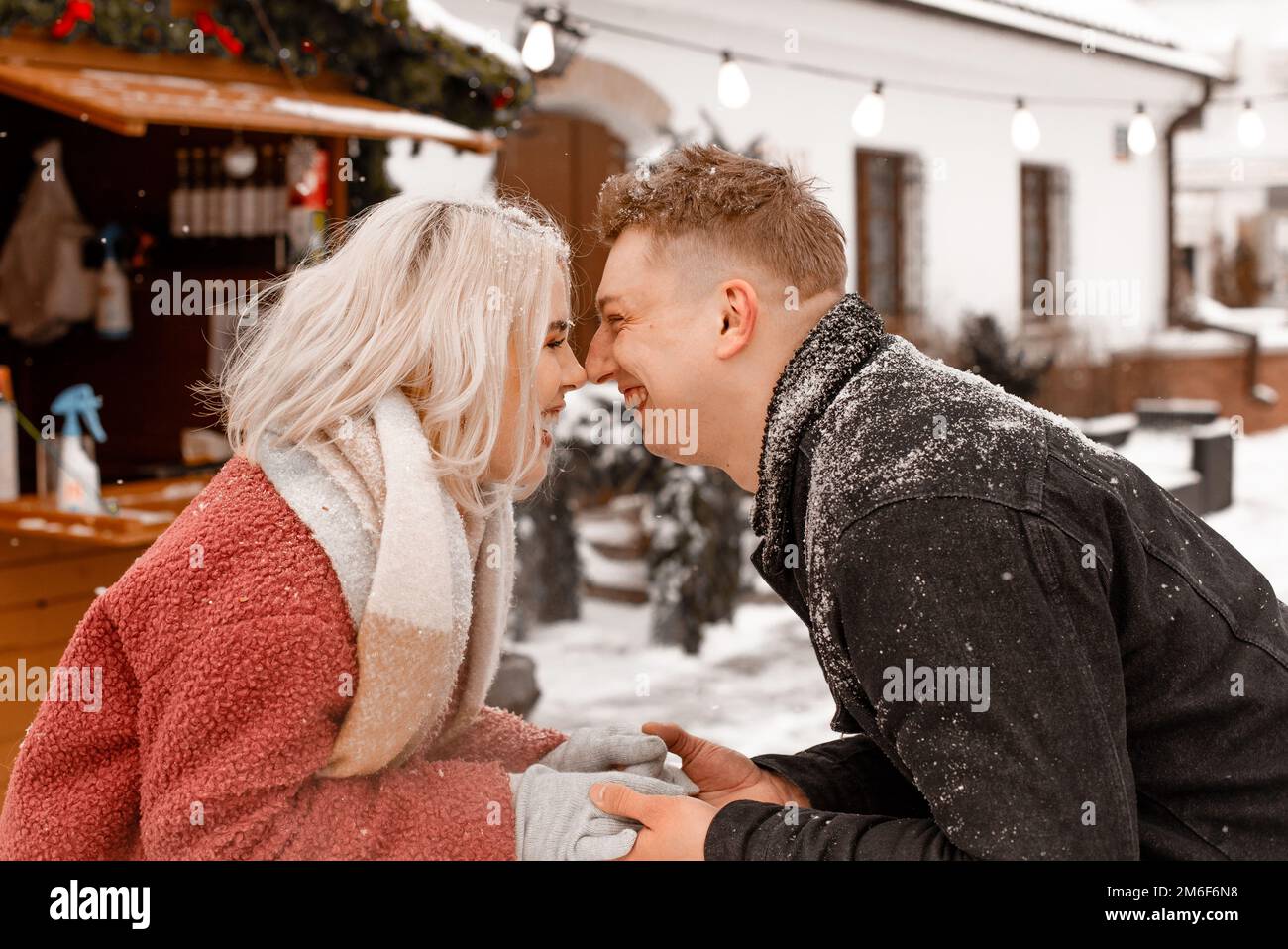 Felice giovane coppia in piedi al tavolo al mercato di Natale all'aperto. Vacanza d'amore a tema San Valentino. Emozione romanticismo di happine Foto Stock