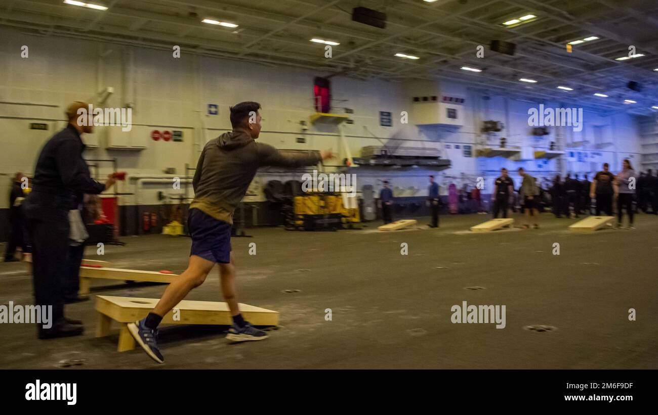 220427-N-EE352-1121 PACIFIC OCEAN (27 aprile 2022) i marinai partecipano a un torneo di corn hole nella baia hangar della portaerei di classe Nimitz USS Carl Vinson (CVN 70), aprile 27. Vinson sta attualmente conducendo operazioni marittime di routine nell'Oceano Pacifico. Foto Stock