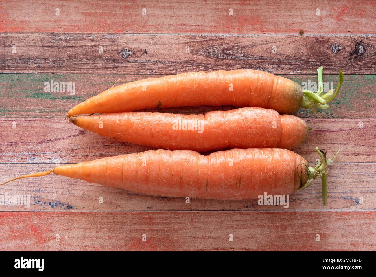 Tre carote su uno sfondo di legno colorato con spazio copia Foto Stock