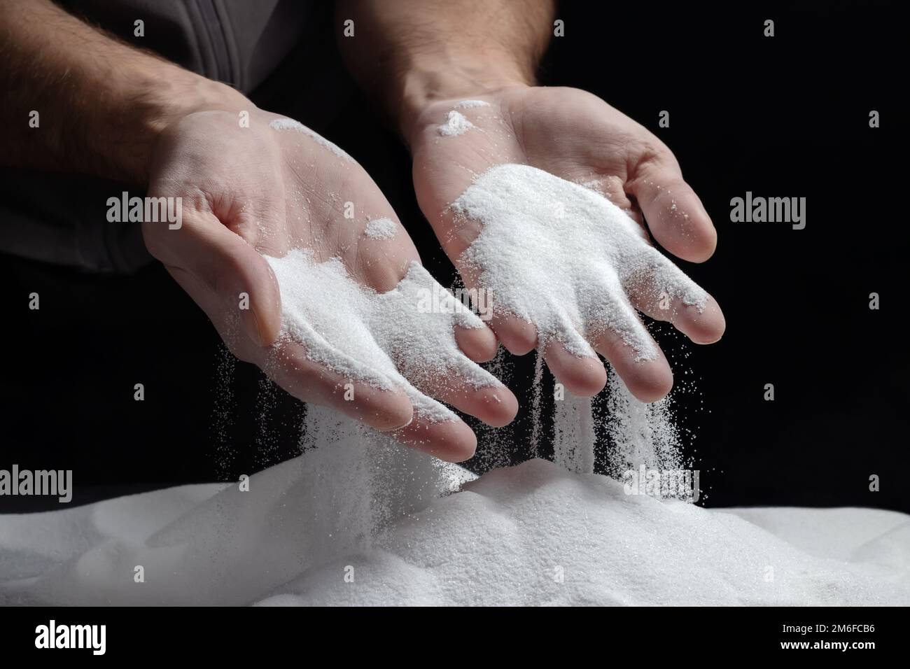 sabbia che scorre attraverso le mani come un simbolo per il tempo di corsa. Foto Stock