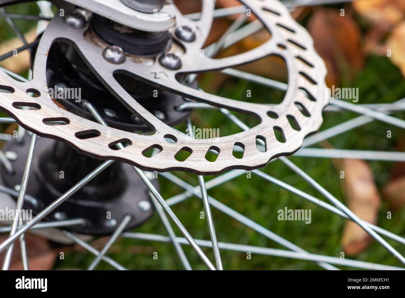 Primo piano dei freni a disco della bicicletta, disco in metallo grigio fissato alla ruota della bicicletta, freni efficaci e diffusi per biciclette di montagna Foto Stock