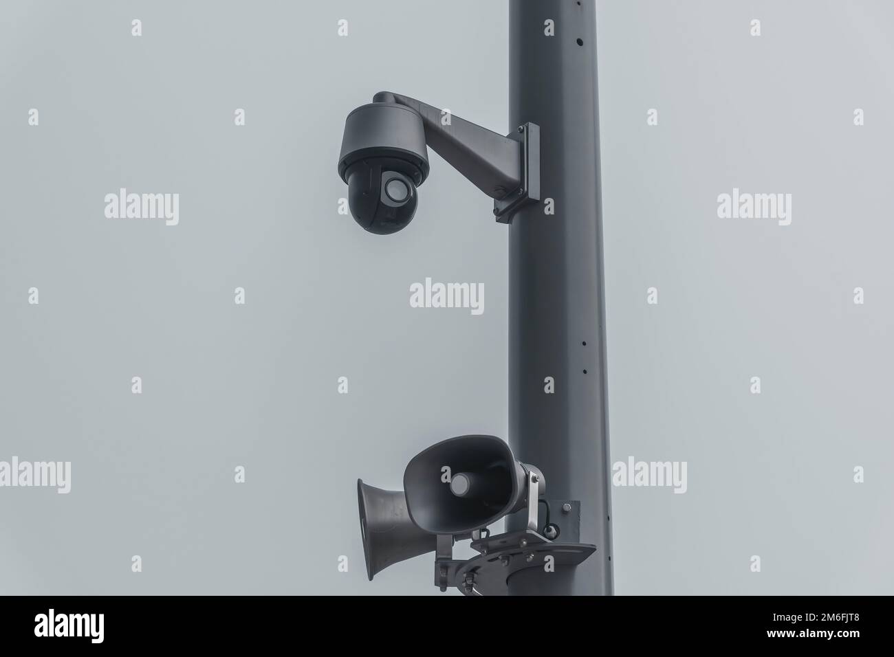 Un primo piano di una telecamera di sicurezza e di altoparlanti su un palo in una giornata di nebbia Foto Stock