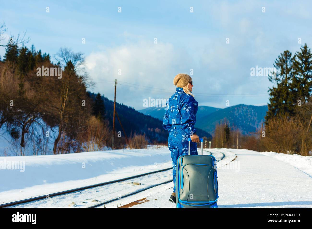donna in tute da sci si trova vicino alla ferrovia Foto Stock