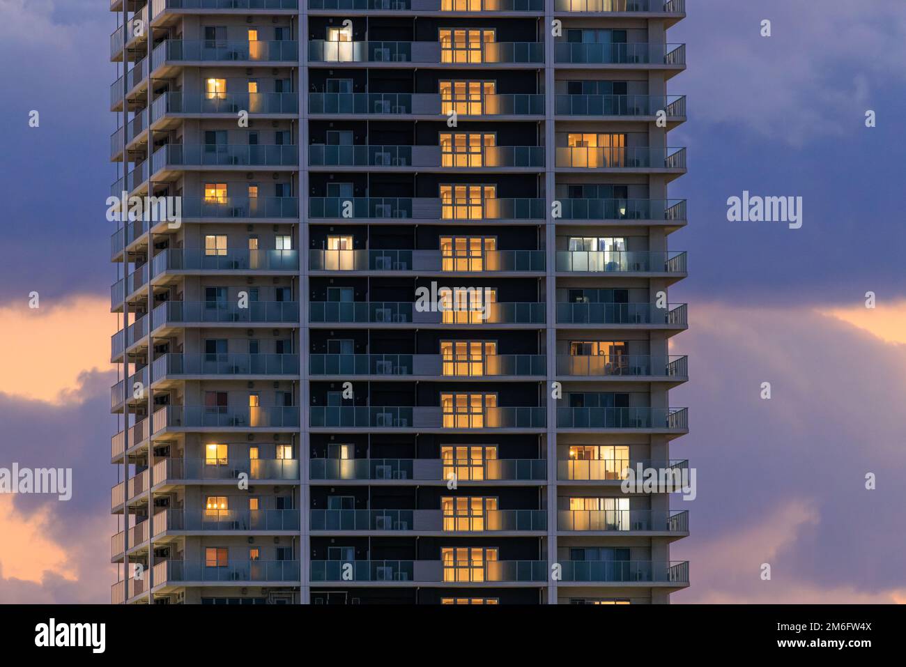 Luci dalla torre di appartamenti di lusso contro il bel cielo tramonto Foto Stock