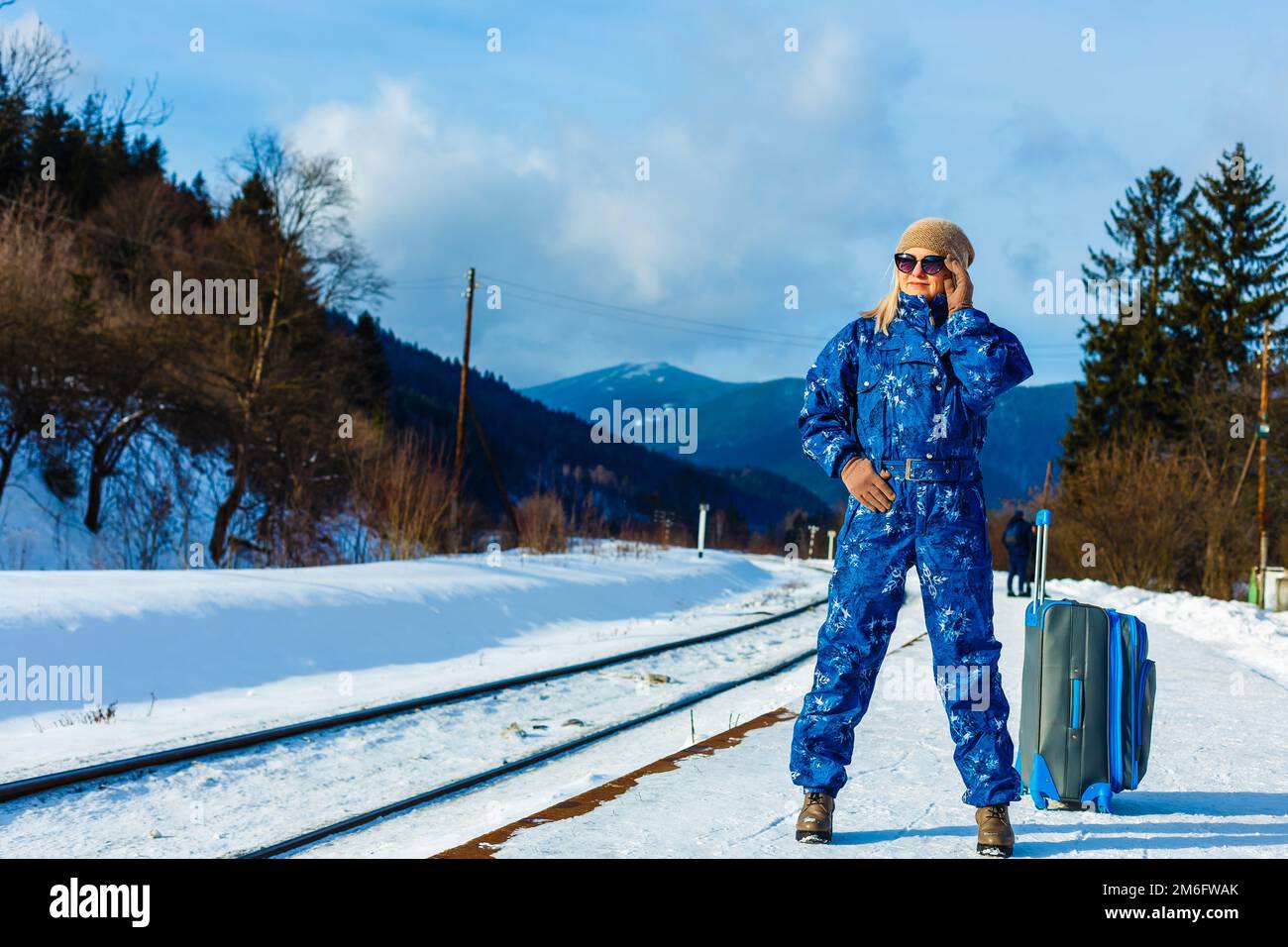donna in tute da sci si trova vicino alla ferrovia Foto Stock