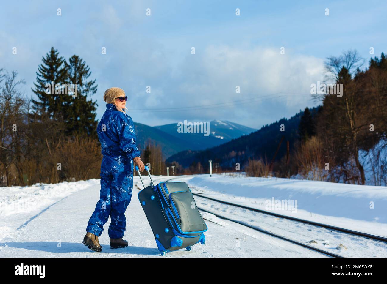 donna in tute da sci si trova vicino alla ferrovia Foto Stock