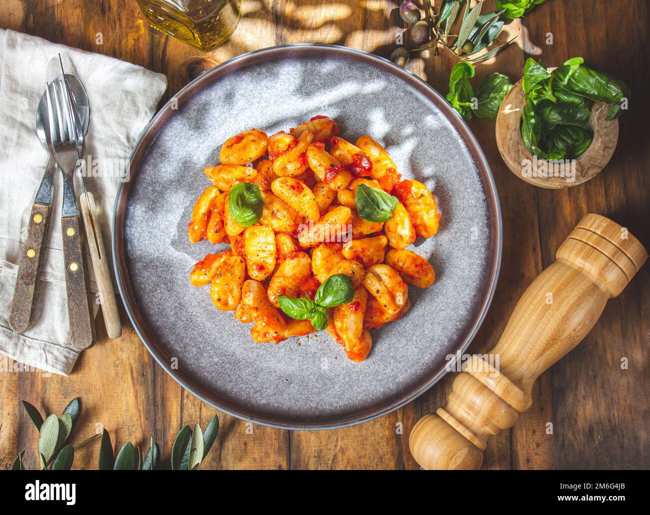 Gnocchi italiani con salsa di pomodoro e basilico su fondo ligneo. Foto Stock