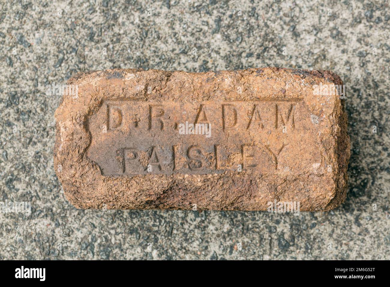 Un vecchio mattone usurato recante il nome del produttore, D R Adam, Paisley, Scotland, UK, Europa Foto Stock