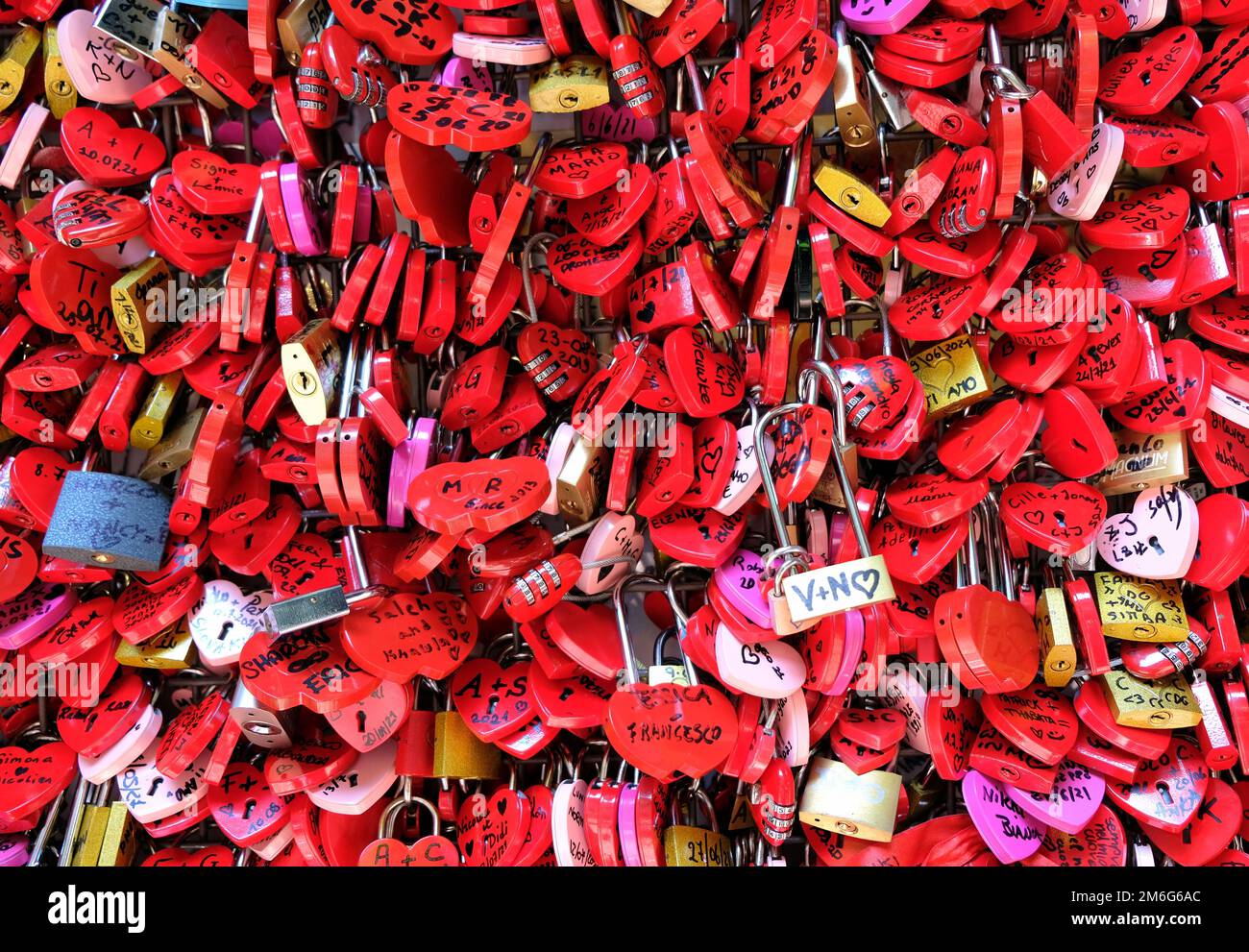 Serrature rosse a forma di cuori su una recinzione Foto Stock