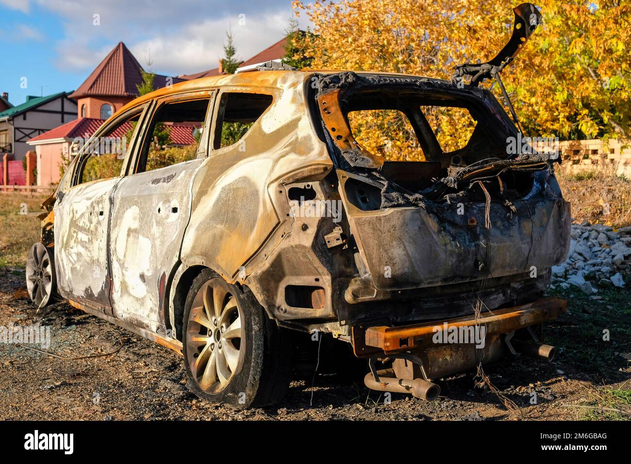 Auto bruciata in strada in autunno Foto Stock