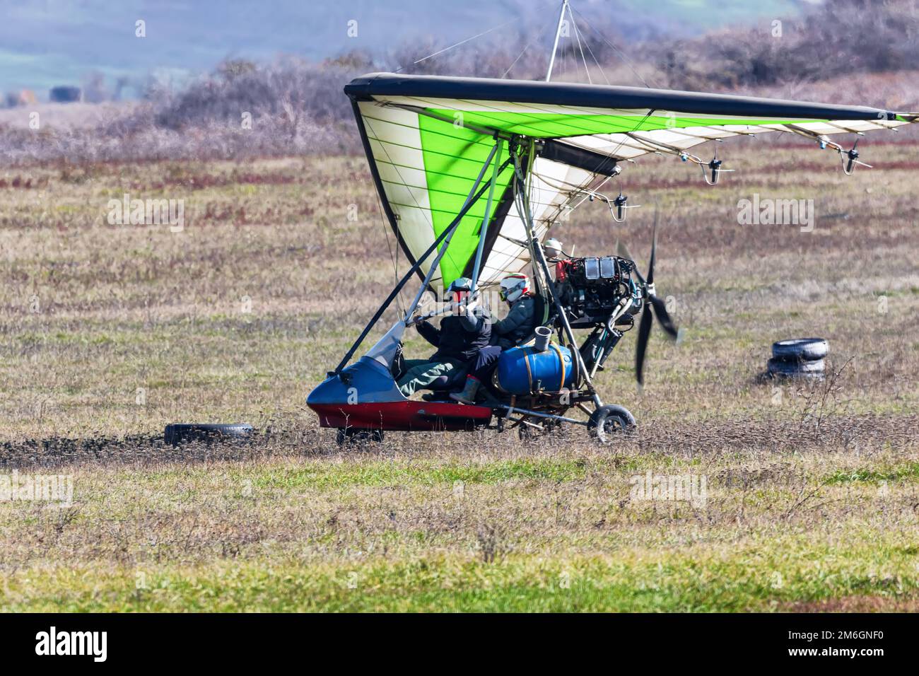 Volo su un parapendio motorizzato in terreno montano Foto Stock