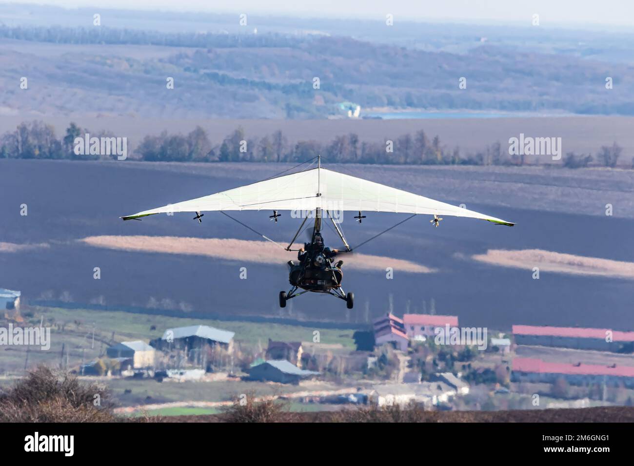 Volo su un parapendio motorizzato in terreno montano Foto Stock