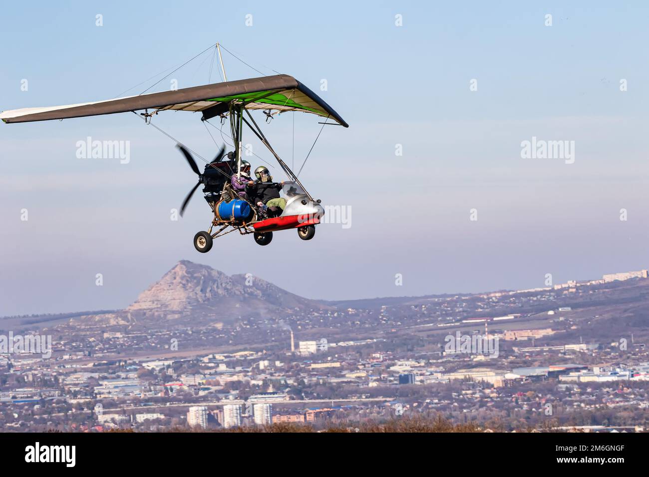 Volo su un parapendio motorizzato in terreno montano Foto Stock