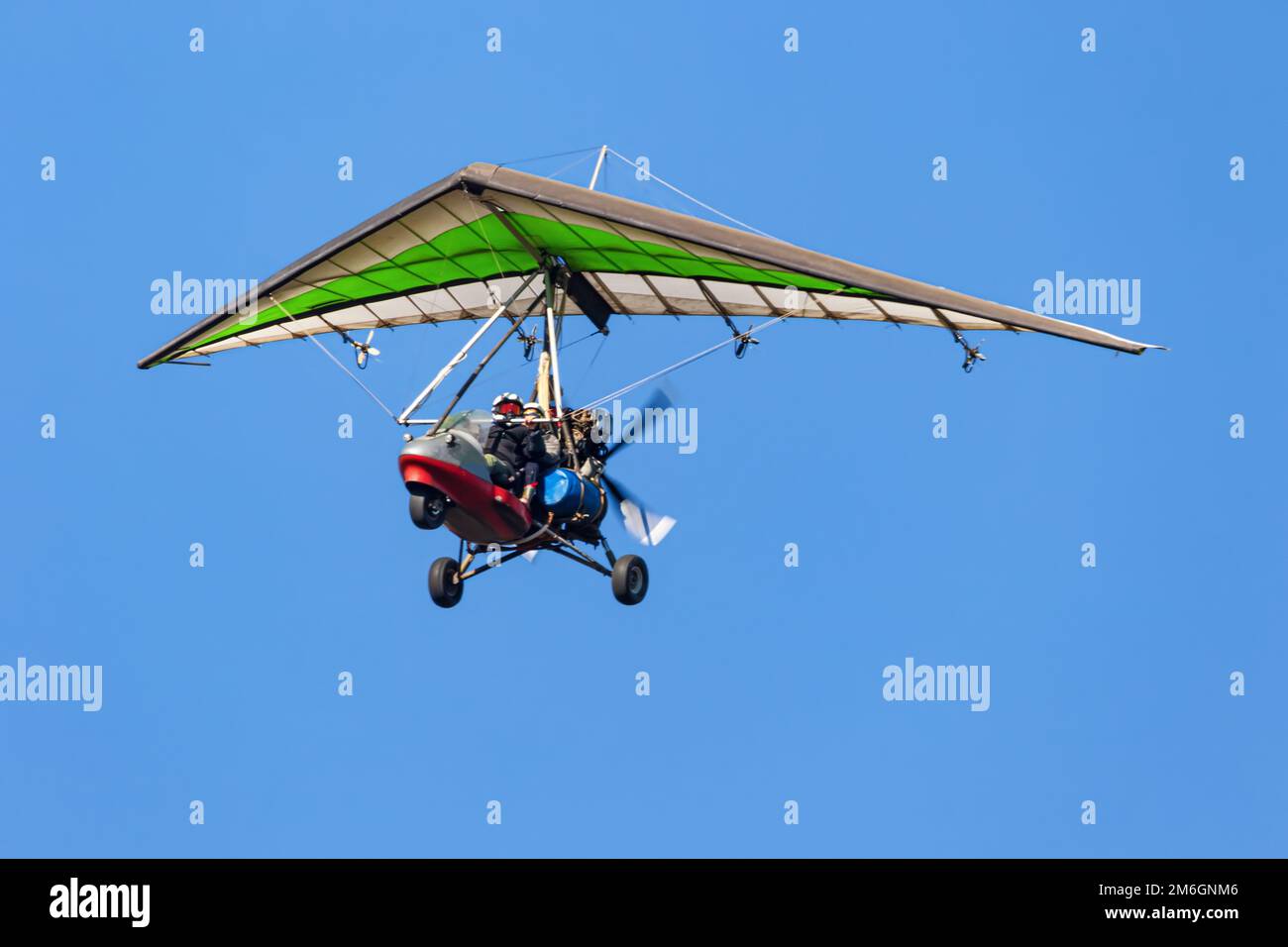 Volo su un parapendio motorizzato in terreno montano Foto Stock