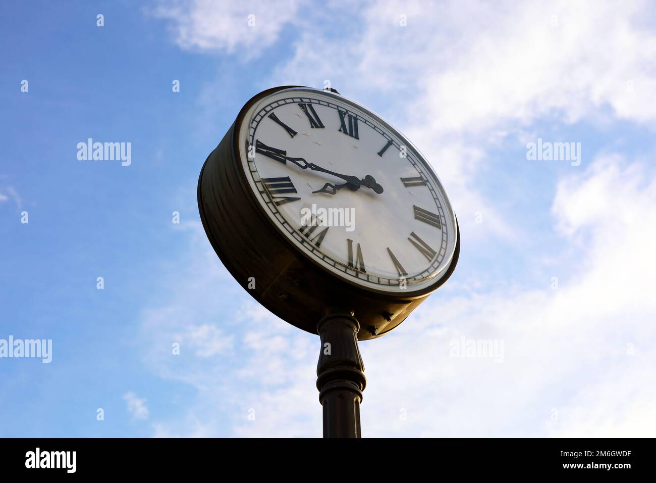 Il quadrante dell'orologio sullo sfondo del cielo blu al tramonto Foto Stock