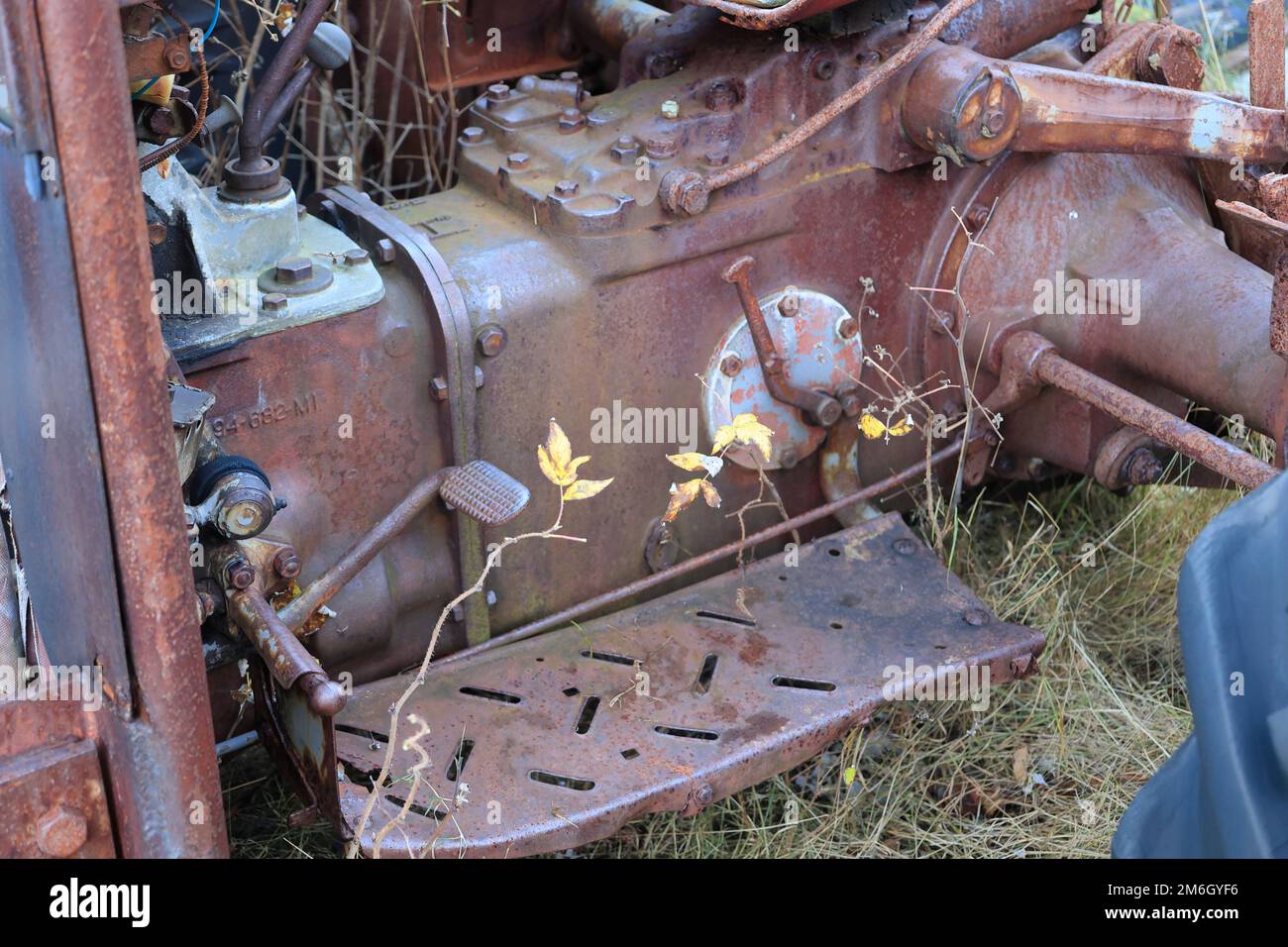 Vecchio trattore arrugginito si trova su un prato Foto Stock