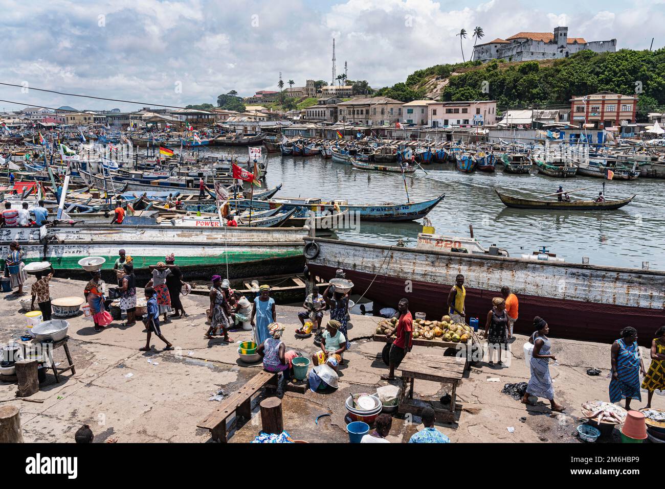 Vista, persone, mercato del pesce, porto di pescatori Elmina, Fort Conraadsburg o anche Fort St Jago in the back, Gold Coast, Ghana Foto Stock