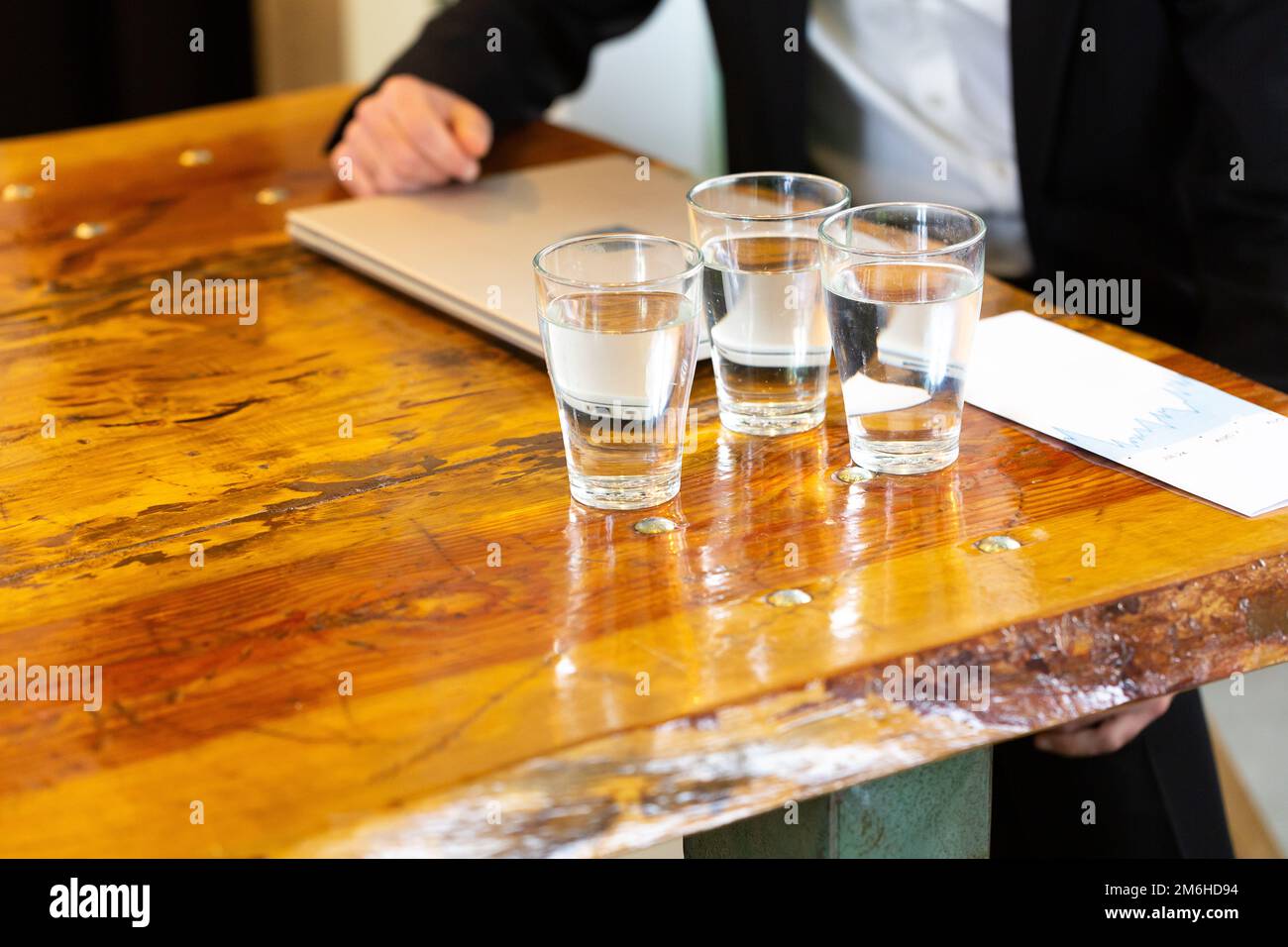 Tavolo in legno con bicchieri d'acqua prelevati da un dispenser. Progetto di eliminazione plastica. Concetto di non plastica e plastica libera per un ecolo sostenibile Foto Stock