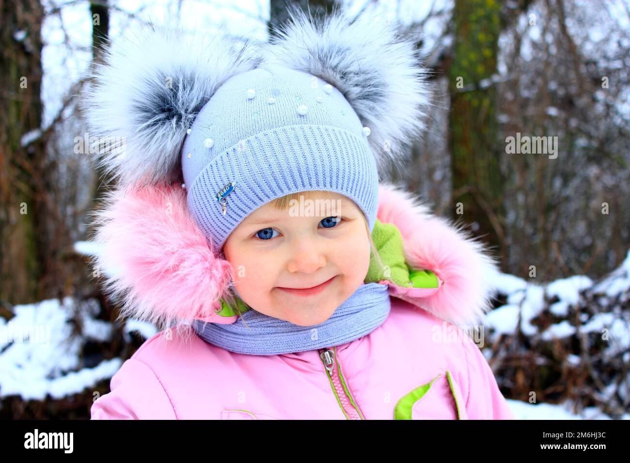 Ritratto di bambino sorridente in divertente berretto invernale con due orecchie divertenti Foto Stock