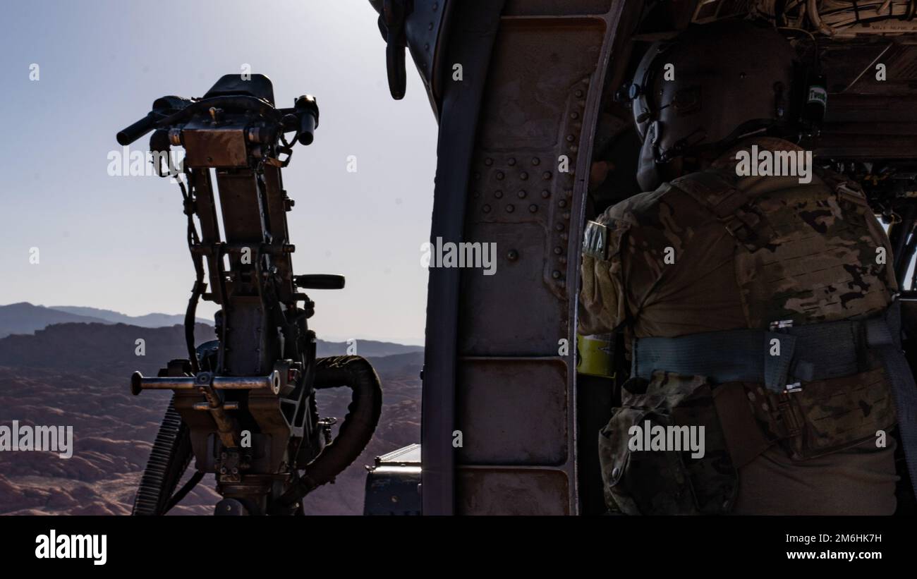 Senior Airman Ty Sarno, aviatore di missioni speciali 66th Rescue Squadron, guarda fuori dalla finestra di una nave Hawk HH-60G prima di condurre una missione di addestramento 2, 2022, 28 aprile 2022, a North Las Vegas, Nevada. Gli SMA 66 RQS sono specialisti altamente addestrati che hanno molteplici ruoli integrali e monitorano tutte le funzioni dell'aeromobile, fornendo al contempo una difesa con armi quando necessario, per consentire al team di completare con successo le proprie missioni. Foto Stock