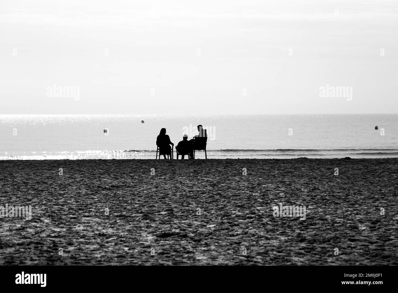 La gente si diverta a sedere sulle sedie e a prendere il sole sulla spiaggia di Levante in una giornata di sole Foto Stock