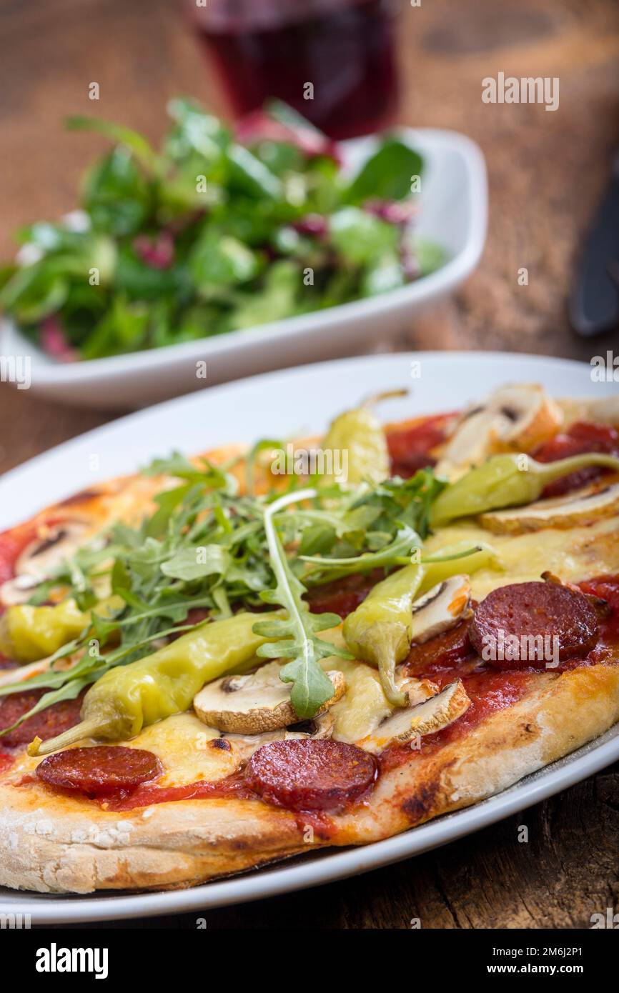 Pizza con salame su legno Foto Stock