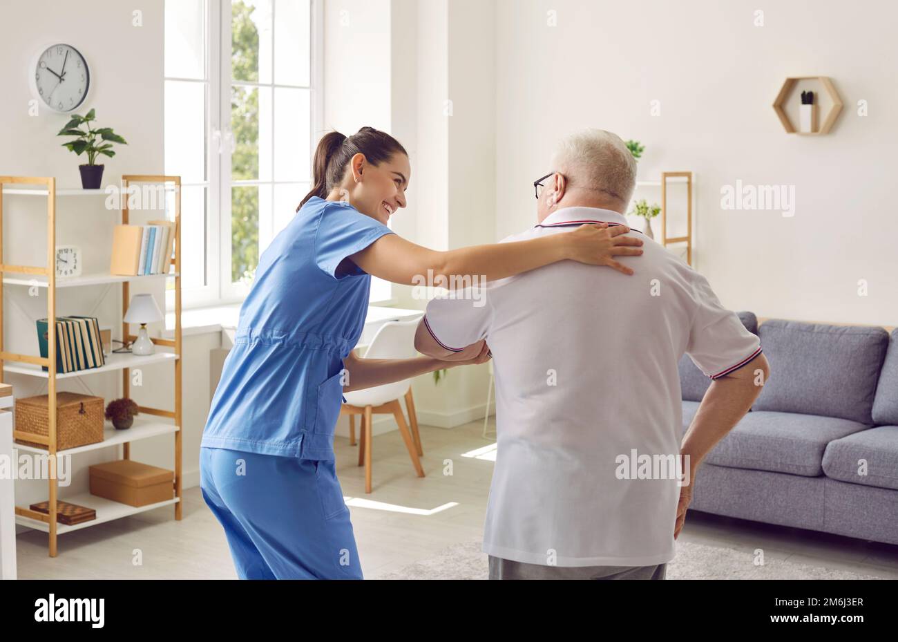 Donna che assiste la paziente anziana con disabilità Foto Stock